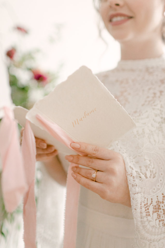 close up of a vow book in a brides hand showing off her wedding ring