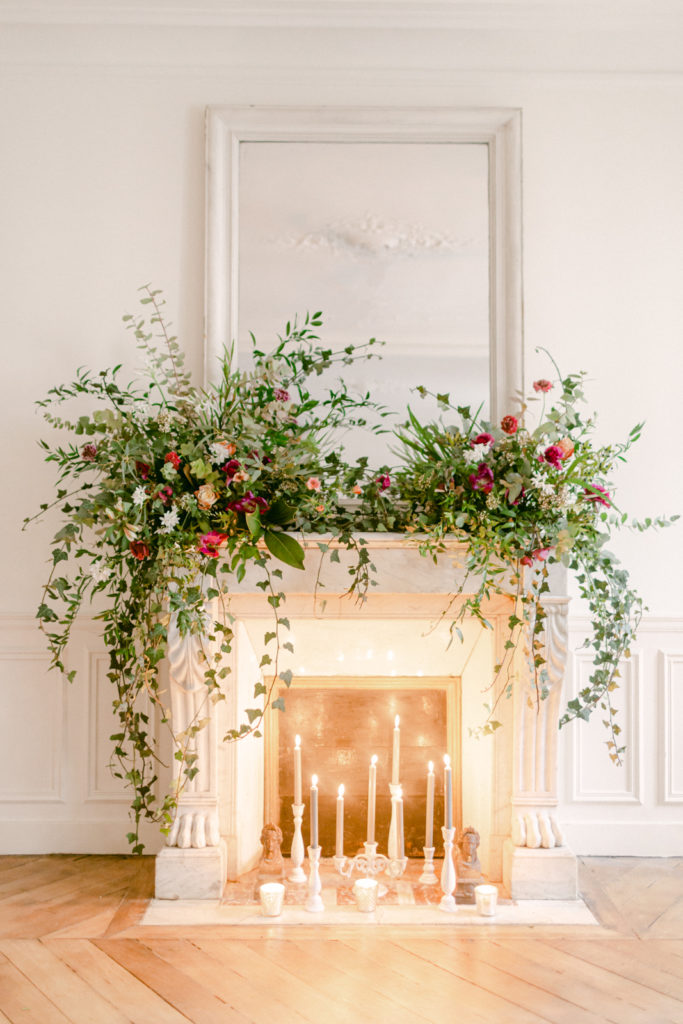 floral arrangement on a fireplace mantel with candles in a paris apartment 