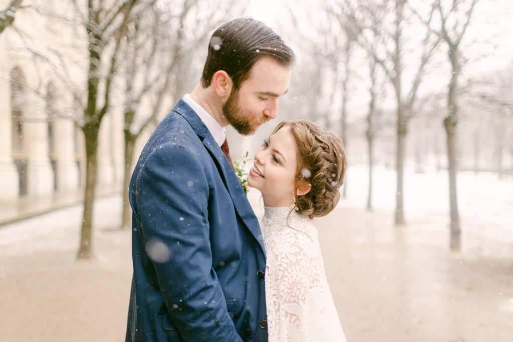 close up of bride and groom facing each other and looking at each other as it snows in Paris