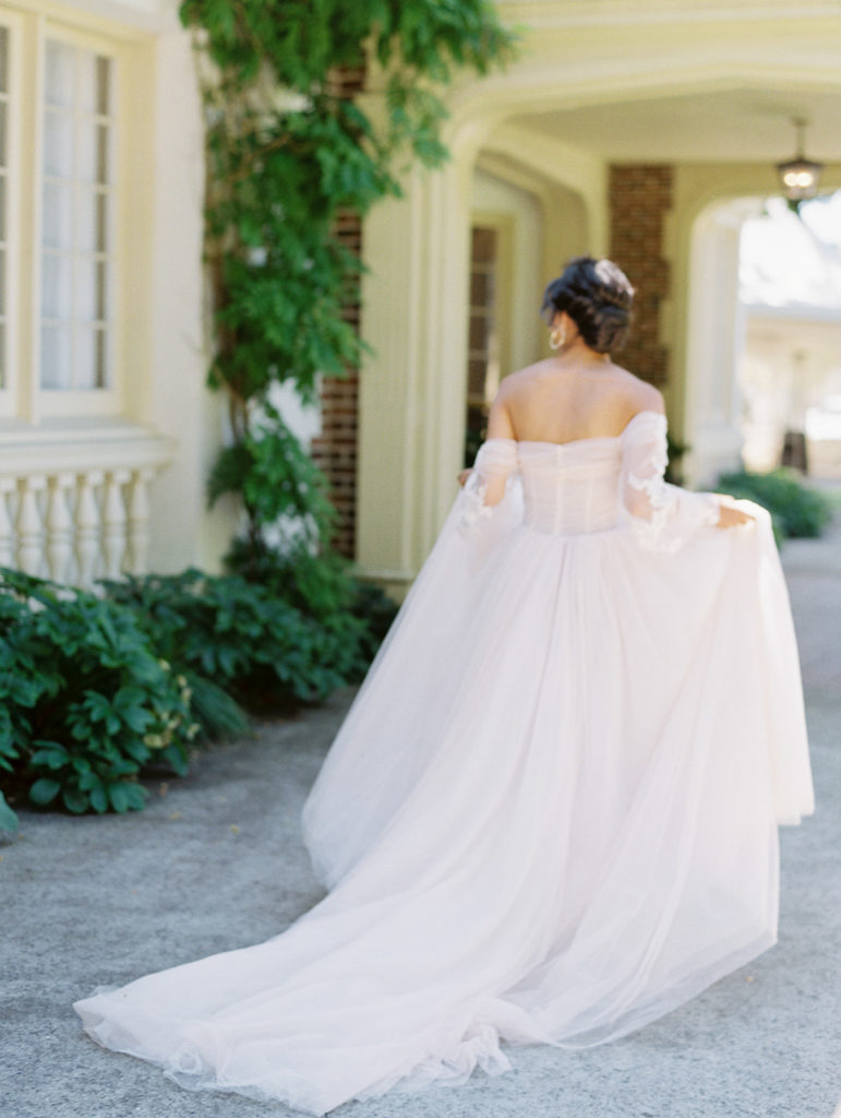 back of bride in pink wedding dress walking away from the camera