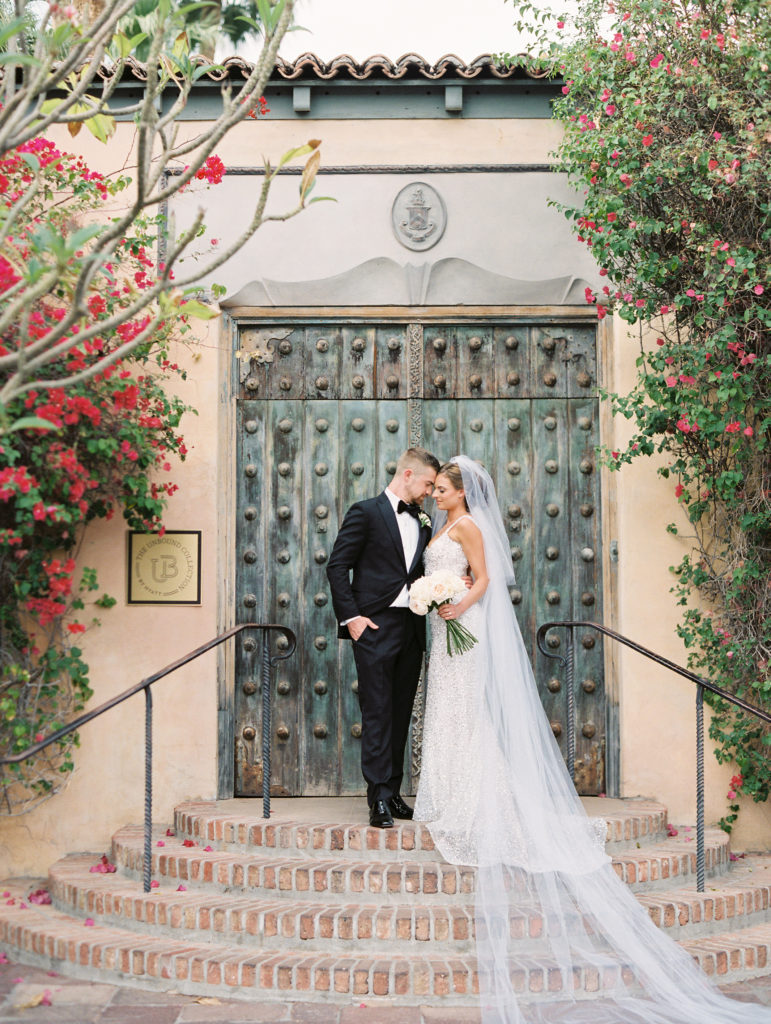 bride and groom standing in front of rustic doors at the Royal Palms Resort in Arizona