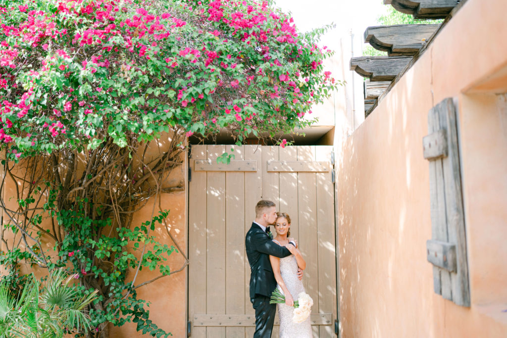 groom embracing bride and giving her a kiss on the forehead at the royal palms resort in Phoenix