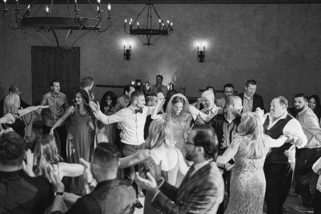 black and white photo of bride and groom dancing with their guests during their reception at the royal palms resort