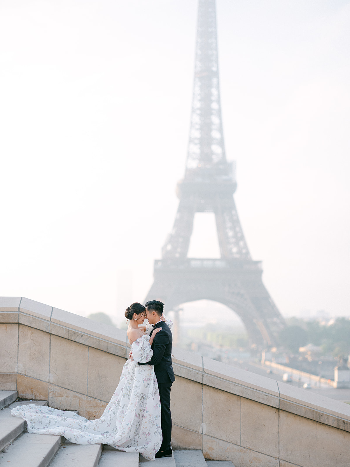 a bride and groom standing in front of the eiffel tower in paris france.
