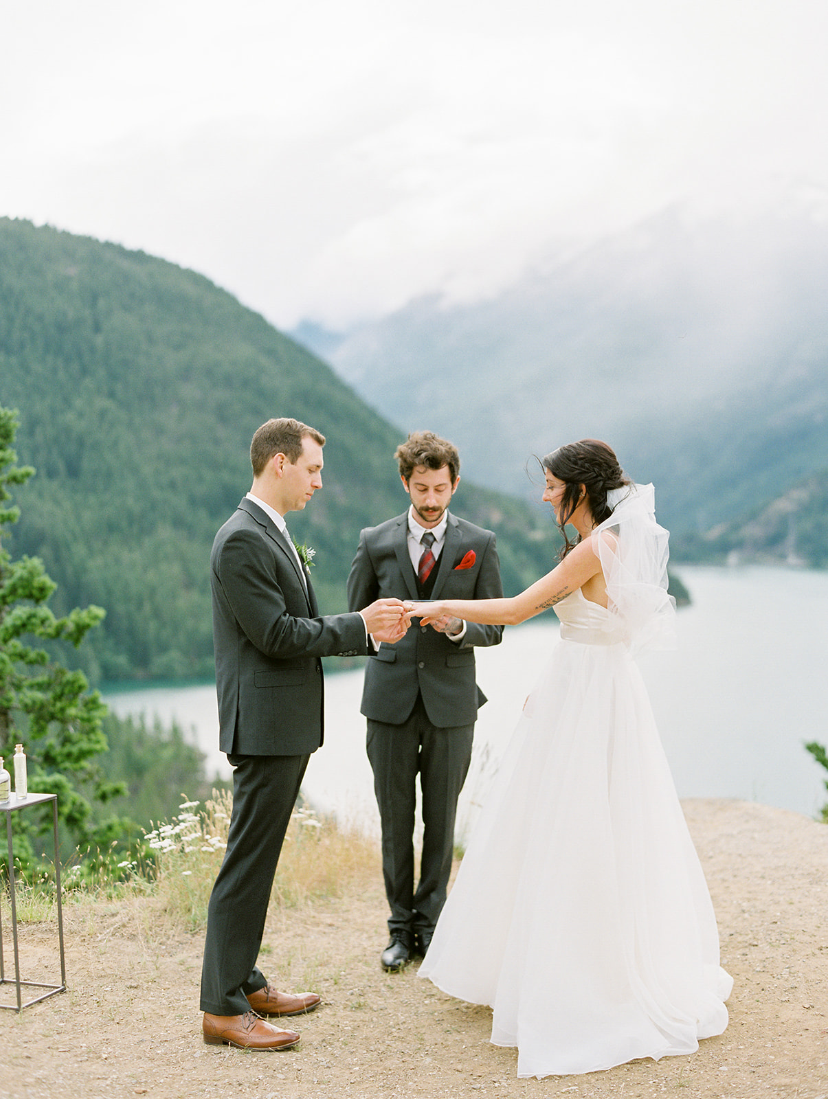 a bride and groom during their wedding ceremony that is overlooking tha cascades and diablo lake