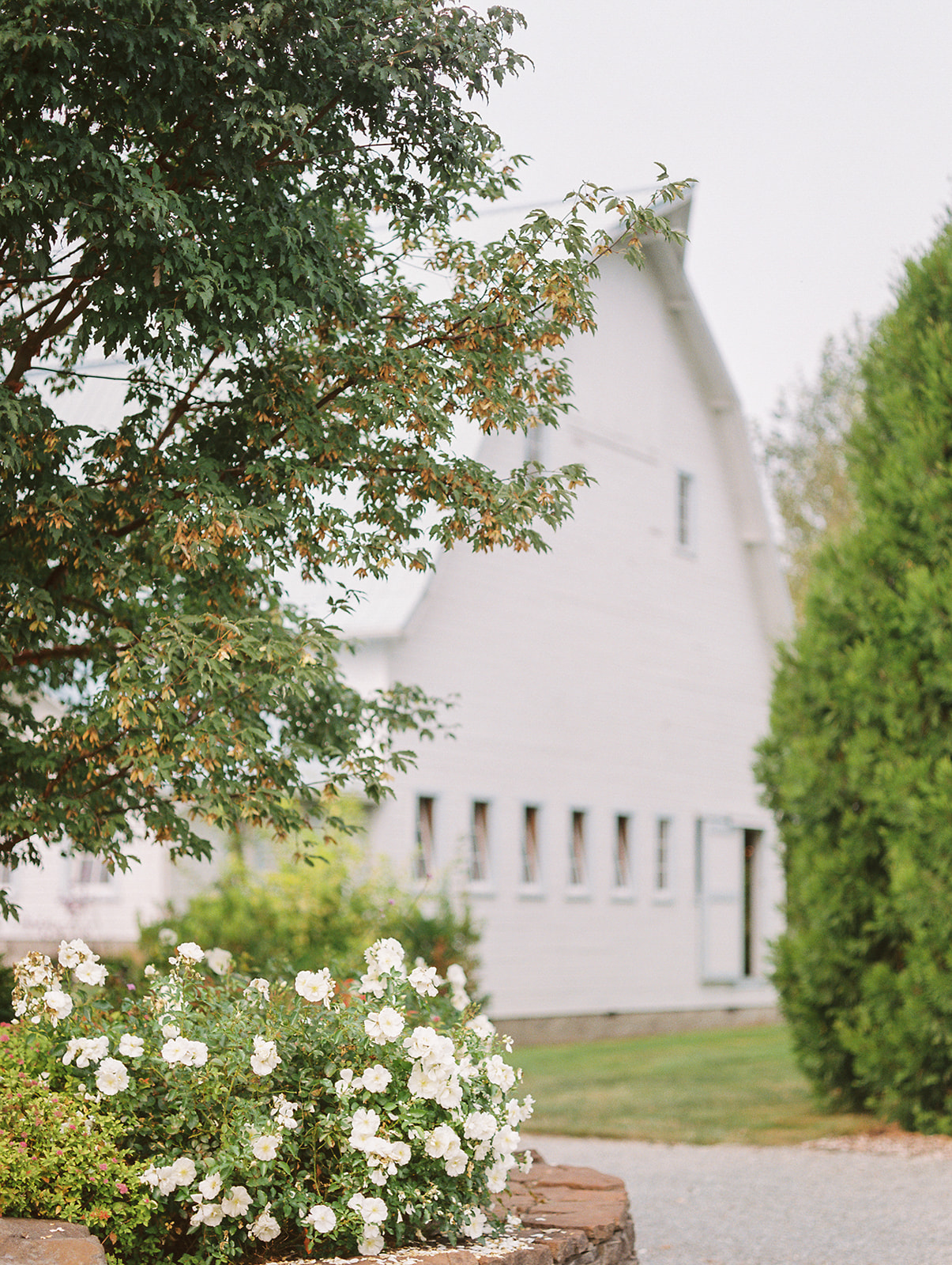 a white barn wedding venue with trees and florals on an overcast day in snohomish washington