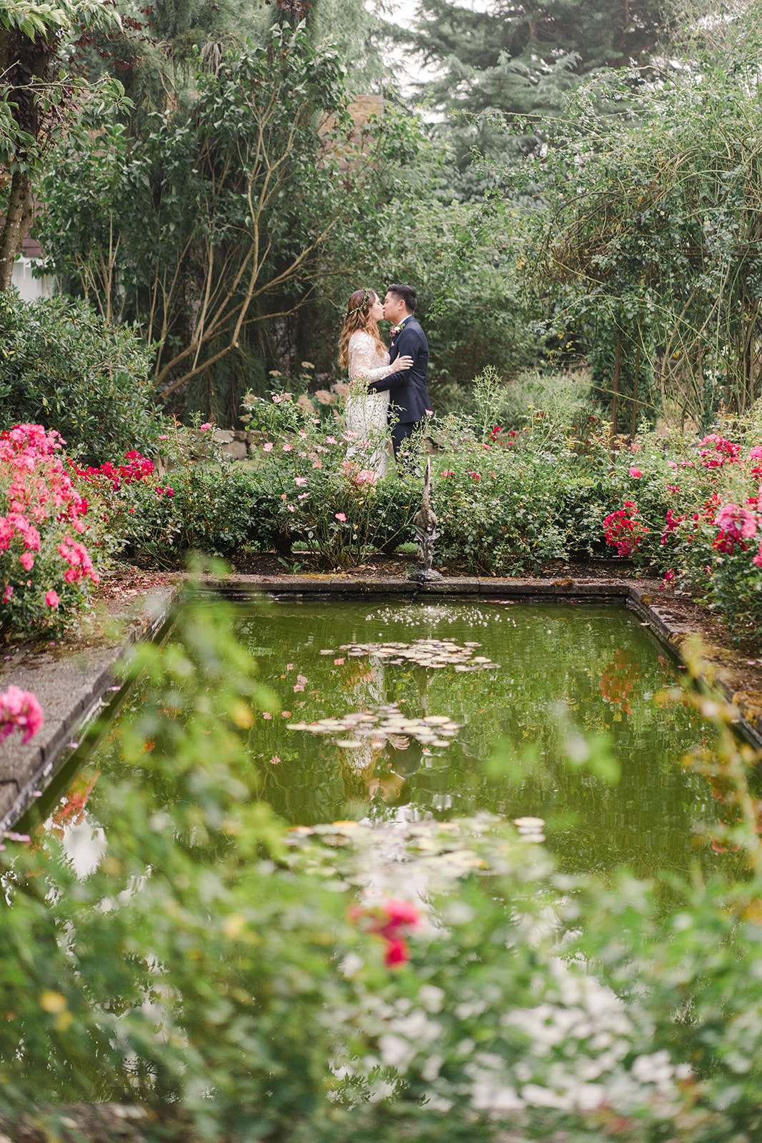 a bride and groom kissing near a garden pool in washington at an outdoor wedding venue