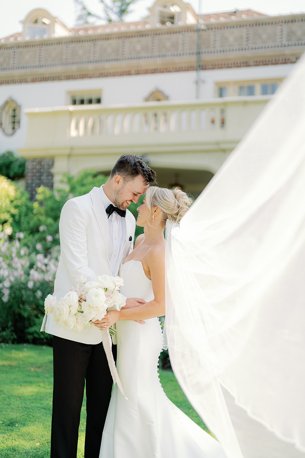 a bride and groom facing each other and smiling while it looks like they are about to kiss at their wedding at lairmont manor