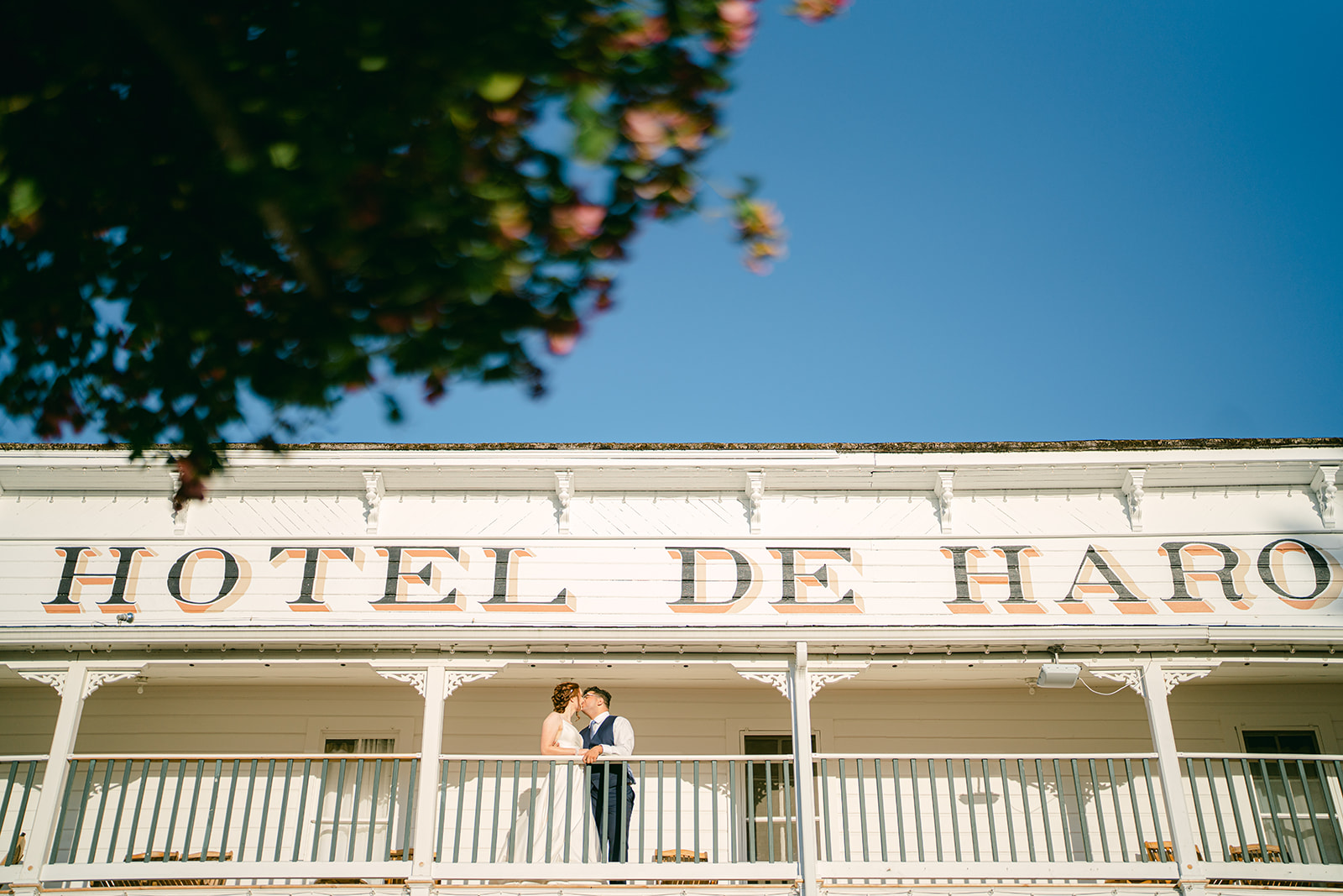 a couple kissing on the balcony of Hotel De Haro at their micro wedding at Roche Harbor Resort