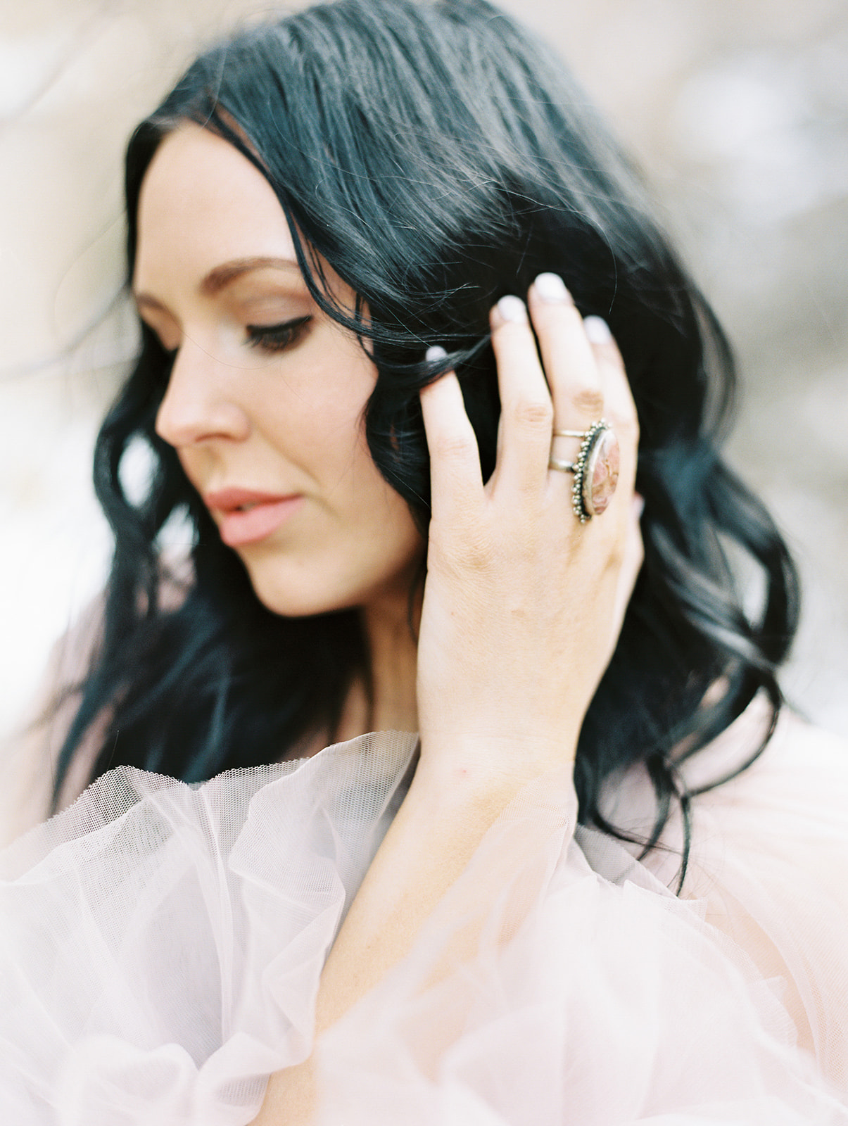 a girl with black hair looking down for her portraits in provo canyon