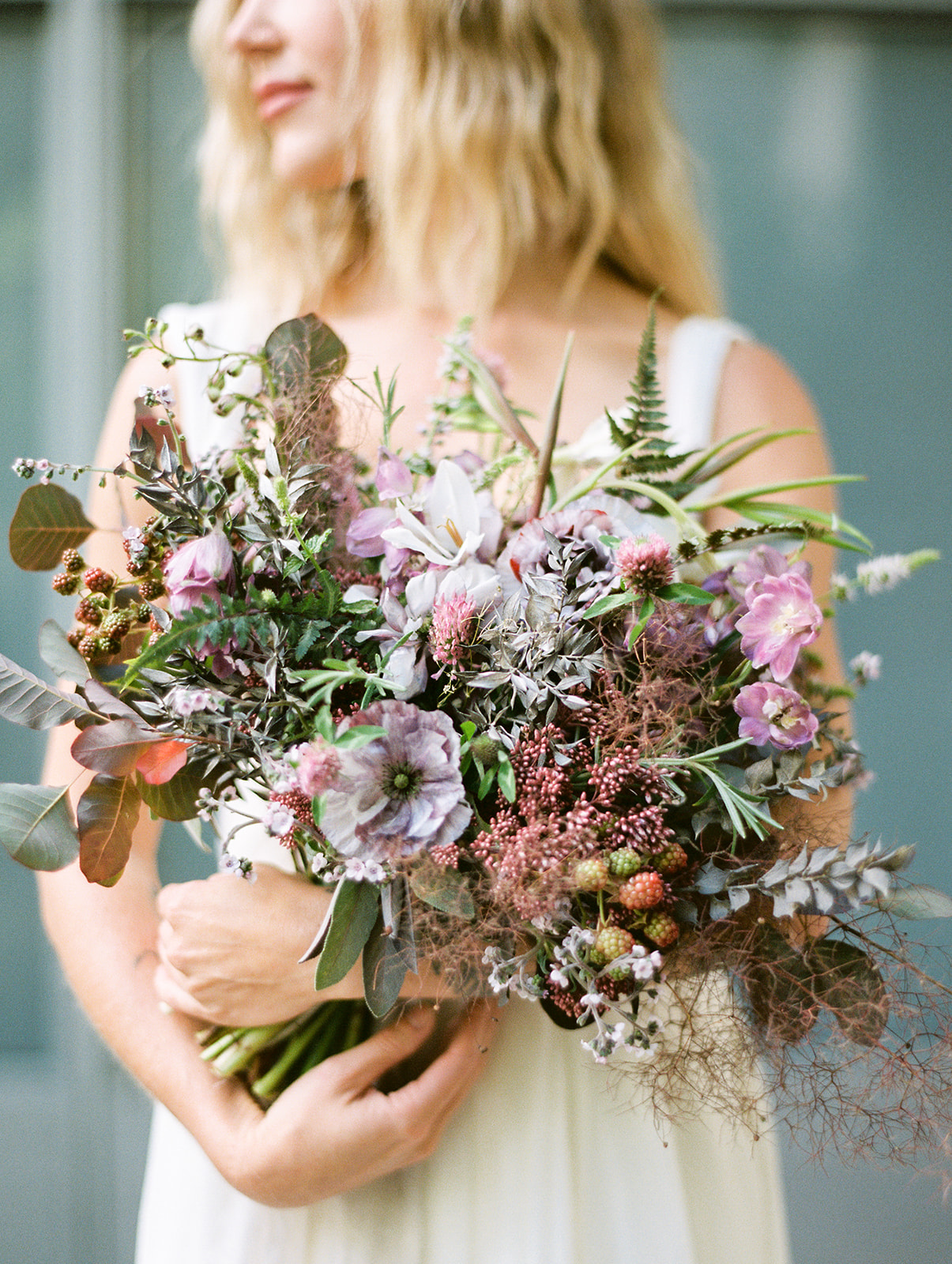 a bride holding a very whimsical floral bouquet